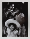 Image of Small Girl with Straw Hat Smiling/ Two Older Girls in the Back, Mexico